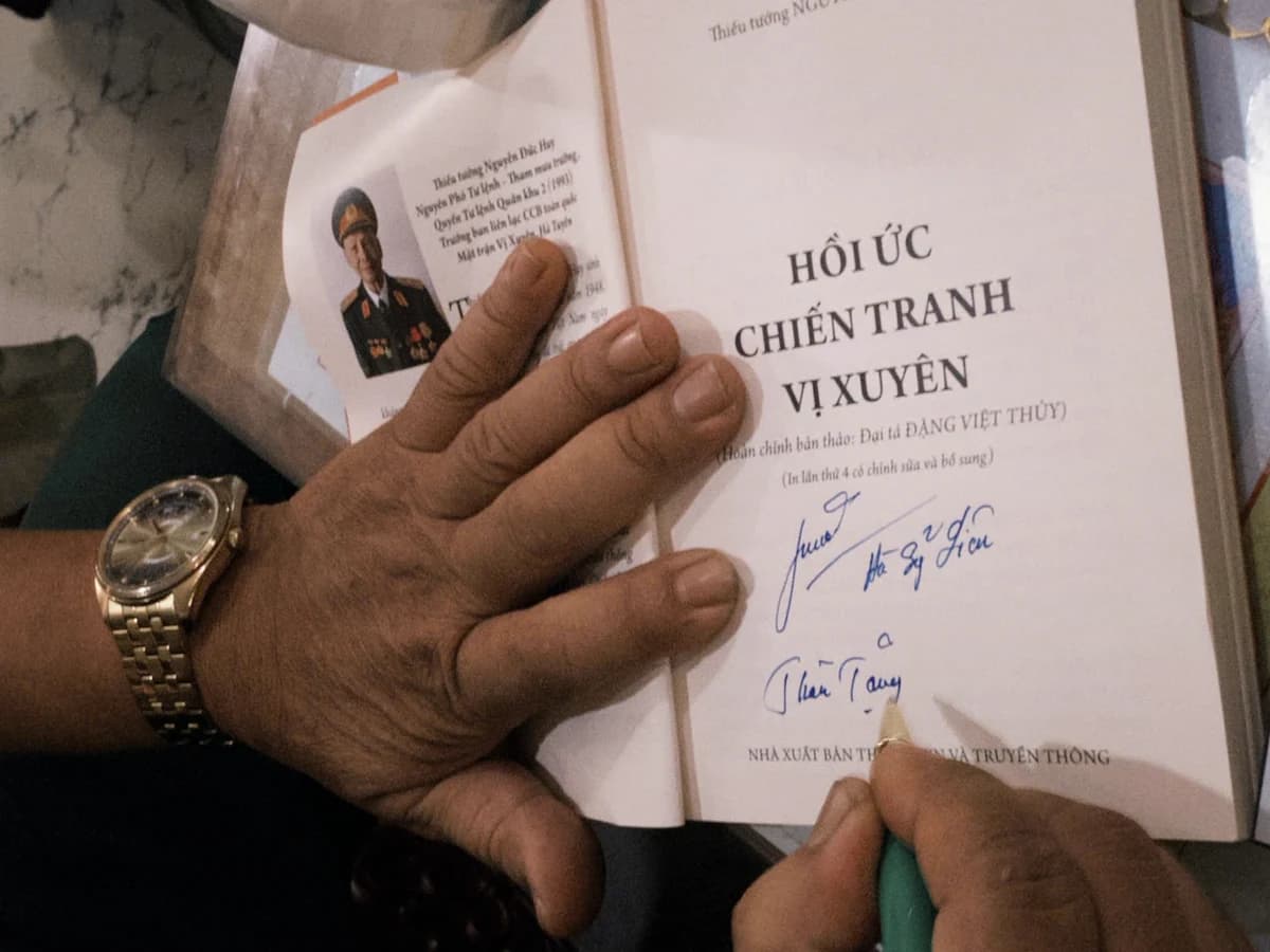Một cuốn sách hồi ức chiến tranh mở trang đề tặng có chữ ký.